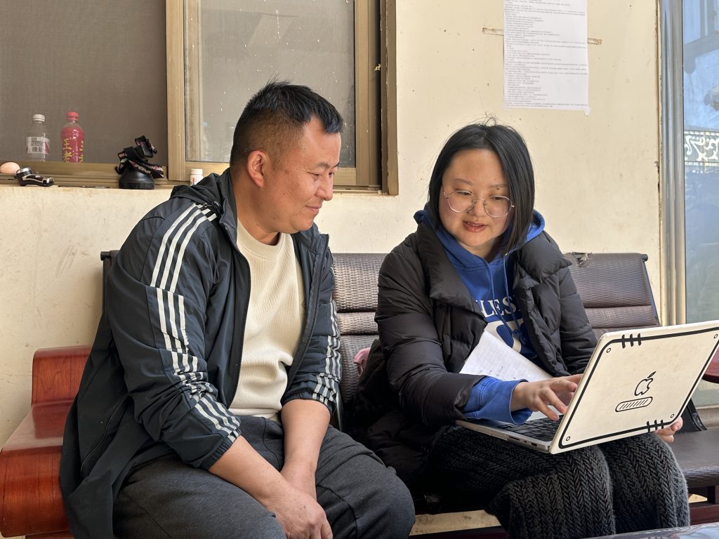Miao musician Zhang Hongming and Yalun Yang working together to proofread Miao lyrics on 12 February 2026