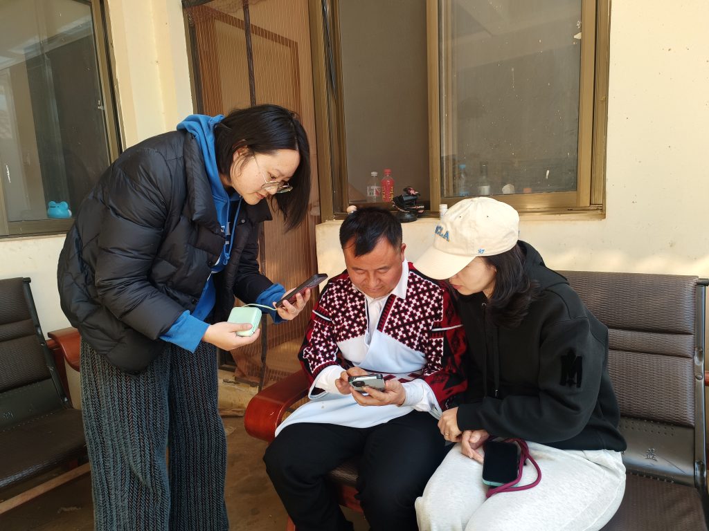The ECura project team teaches Zhang Hongming how to use the ECurator mobile app.